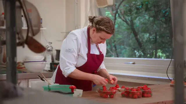 Konditorin schneidet Erdbeeren in der Backstube des Café Osterspey – Szene aus dem Imagefilm