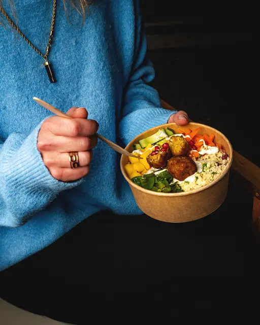 Frau hält eine Bowl mit Falafel von Bordsteinschwalbe – Foodfotografie