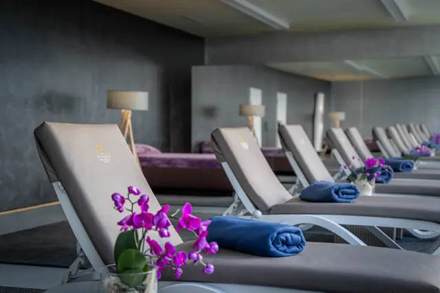 Ruheraum mit Liegen und Orchideen im Wellnessbereich des The Monarch Hotel – Hotelfotografie